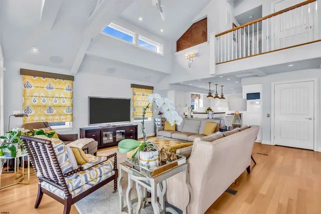 a living room with furniture large windows and view of chandelier