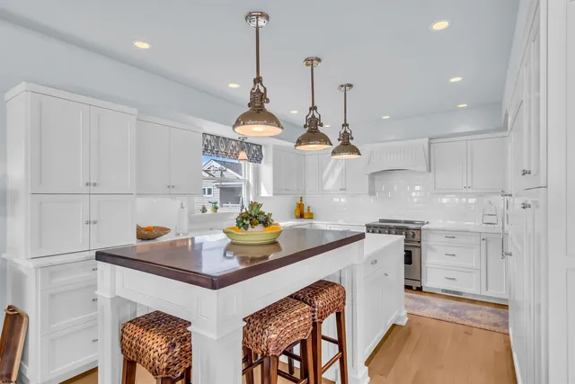 a kitchen with stainless steel appliances granite countertop a stove and a chandelier