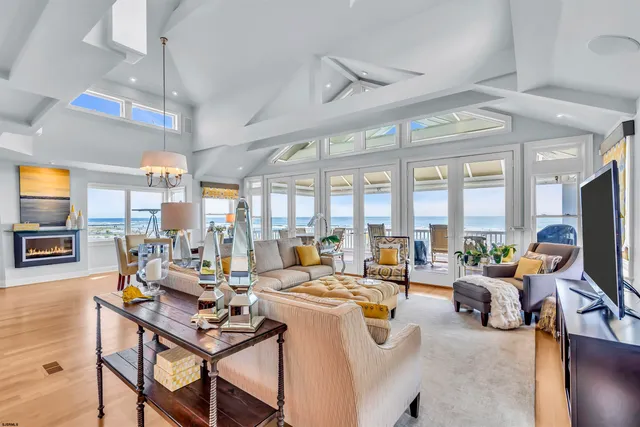 a living room with furniture kitchen view and a chandelier