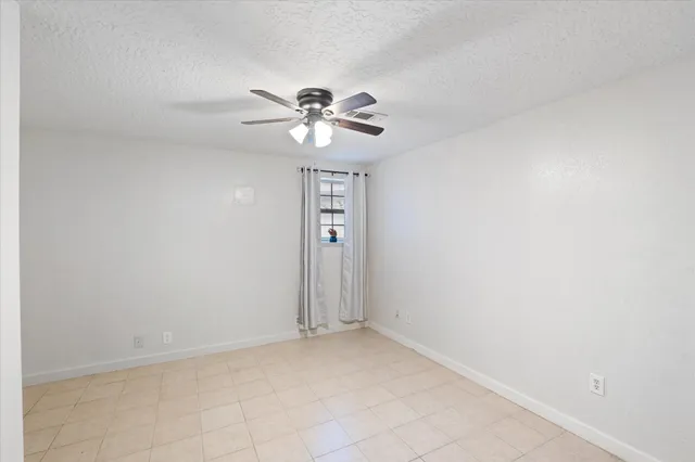an empty room with a fan and a ceiling fan