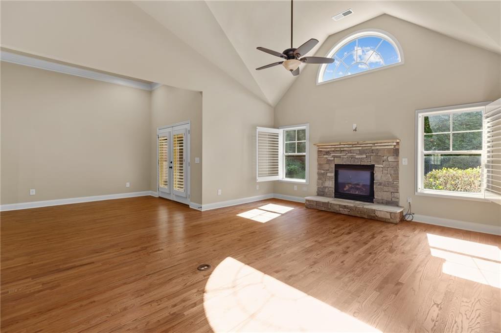 3195 Stonecrest Drive Cumming, GA 30041 - Photo 25 of 63 an empty room with wooden floor fireplace and windows