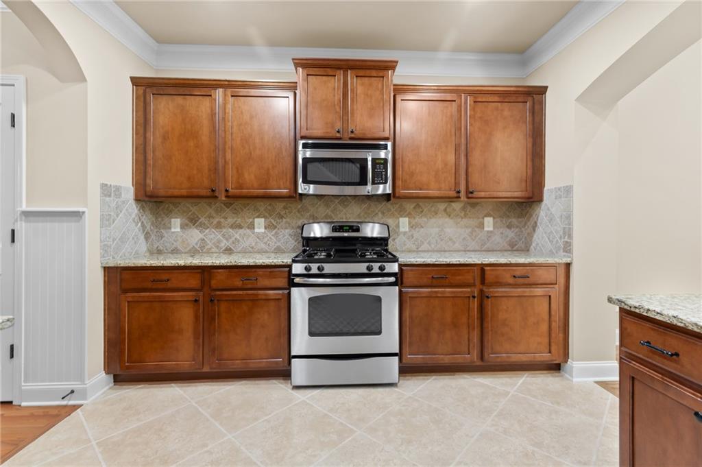 3195 Stonecrest Drive Cumming, GA 30041 - Photo 31 of 63 a kitchen with stainless steel appliances granite countertop a stove a sink and a microwave