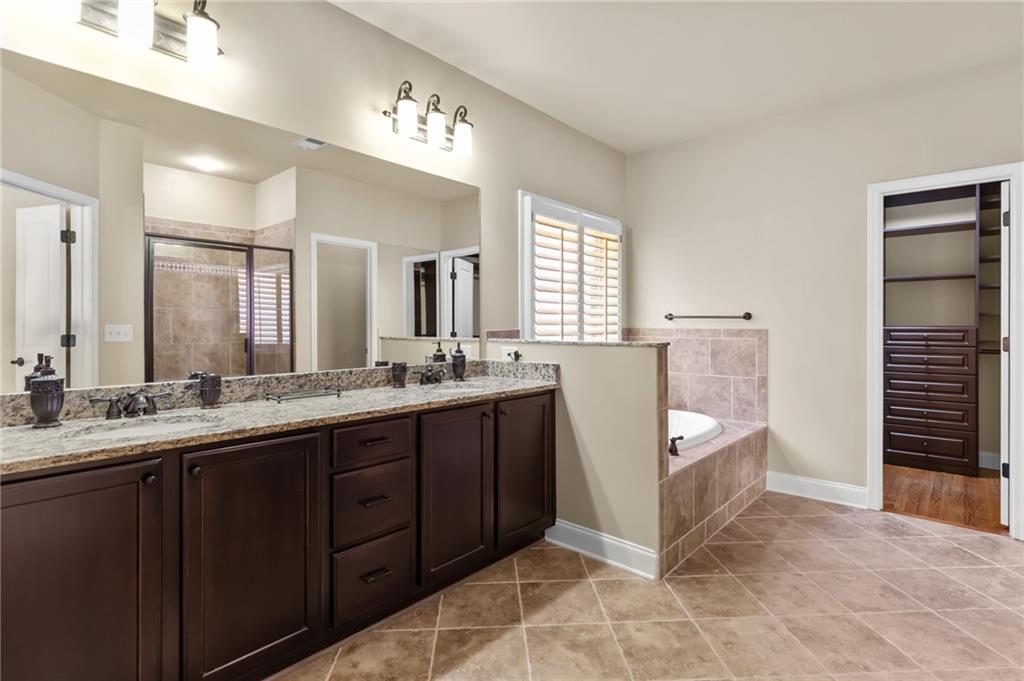 3195 Stonecrest Drive Cumming, GA 30041 - Photo 38 of 63 a spacious bathroom with a double vanity sink a mirror and a bathtub