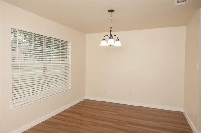 a view of a livingroom with wooden floor and a window