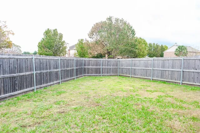 a view of a yard with a small barn and wooden fence