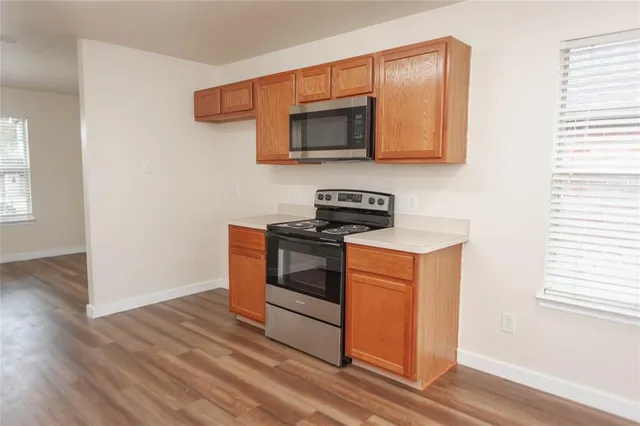 a kitchen with stainless steel appliances a stove microwave and sink