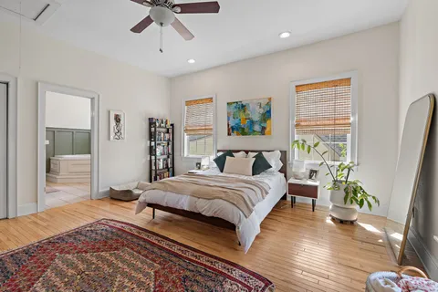 a bedroom with a bed chandelier and a window