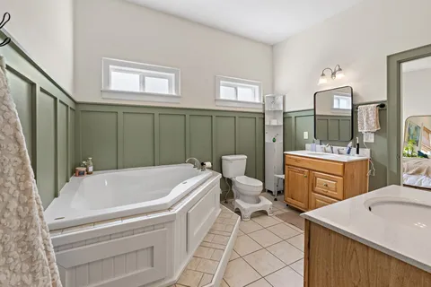 a bathroom with a sink a toilet and mirror