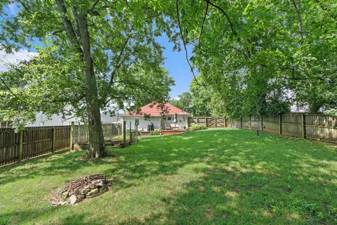 a view of backyard of house with green space