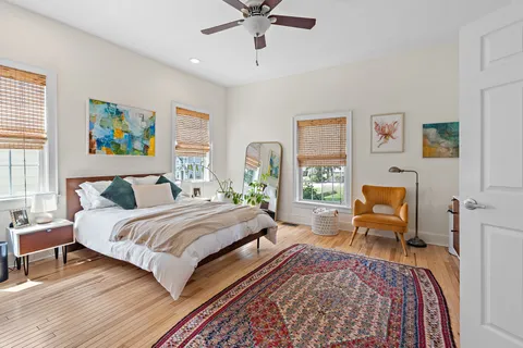 a bedroom with a bed and wooden floor