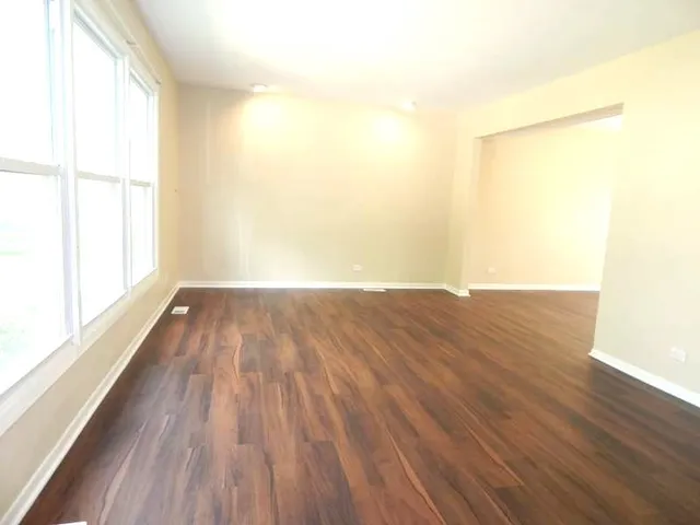 a view of a room with wooden floor and a window