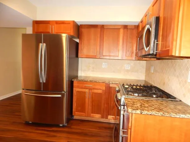 a kitchen with stainless steel appliances granite countertop a refrigerator and a stove