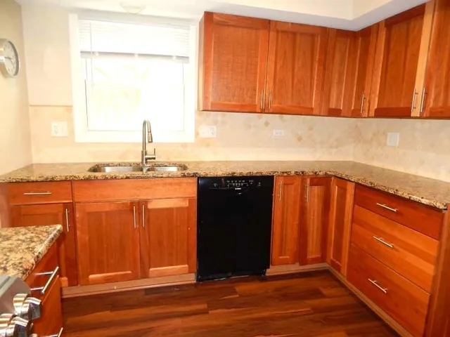 a view of a kitchen with wooden floor and a sink