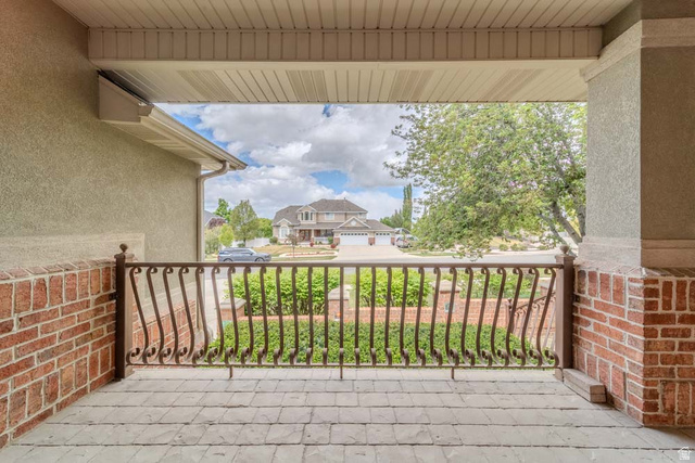598 Hollow Creek Road Draper, UT 84020 - Photo 17 of 110 Covered patio featuring a wrought iron railing, brick accents, and stamped concrete flooring