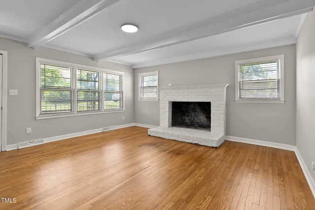 a view of empty room with wooden floor and fireplace