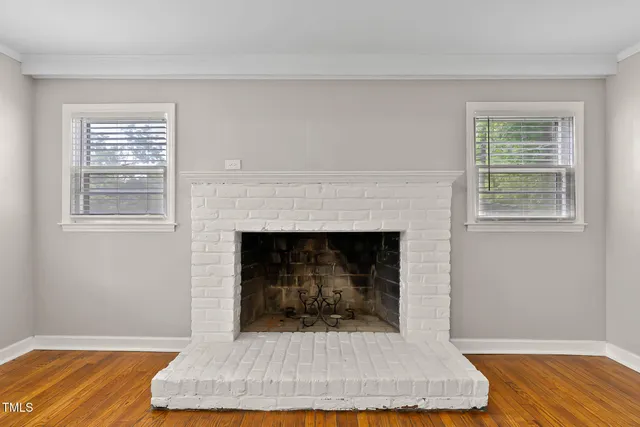 a living room with a fireplace and wooden floor