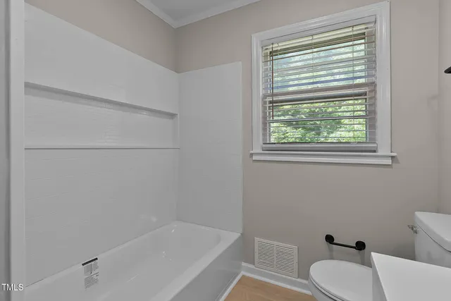 a white bath tub sitting next to a toilet