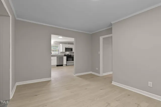 a view of a kitchen with a sink and an empty room