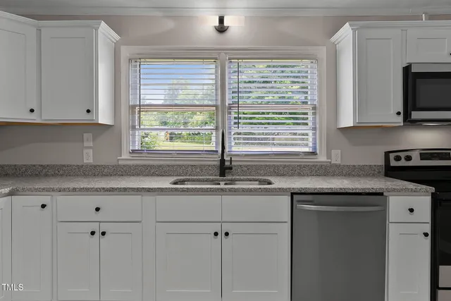 a kitchen with granite countertop a sink and a window
