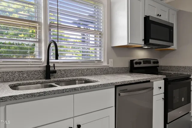 a kitchen with granite countertop a sink and a window