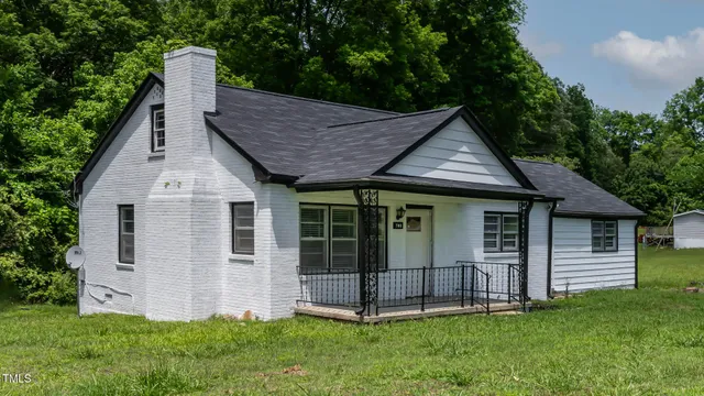 a view of a house with a yard potted plants and large tree