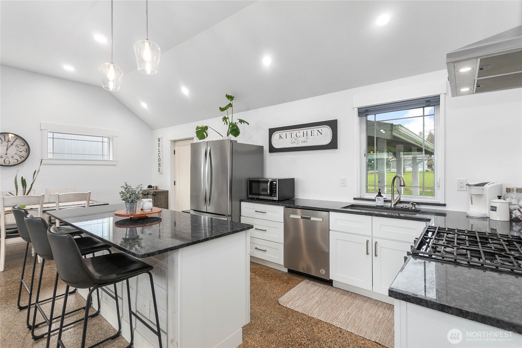 7393 Hannegan Road Lynden, WA 98264 - Photo 11 of 29 a kitchen with stainless steel appliances granite countertop a stove top oven a sink a dining table and chairs