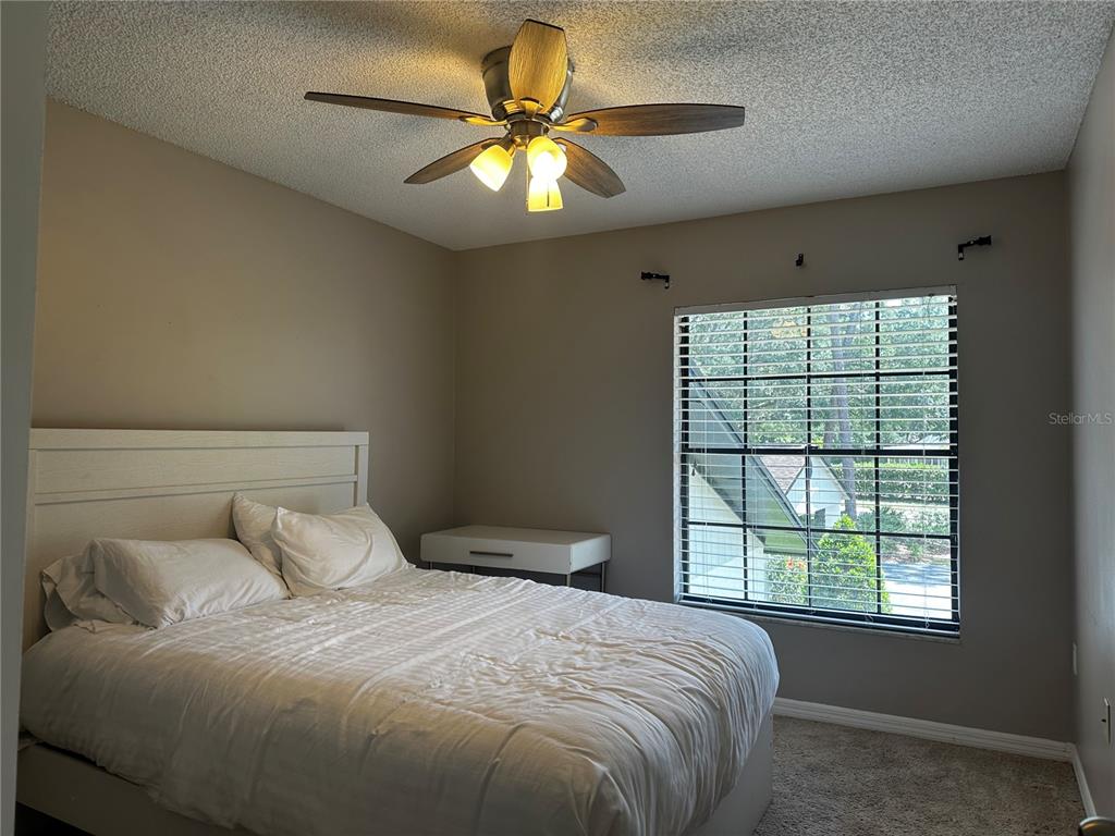 5434 Saddlebrook Way, Unit 3 Wesley Chapel, FL 33543 - Photo 12 of 17 a bedroom with a bed and a chandelier