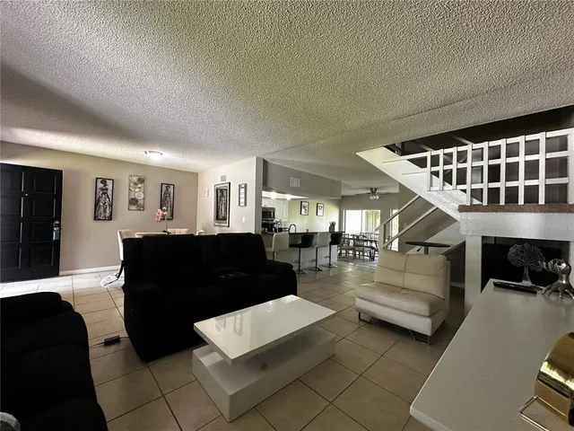 a living room with couches and furniture with kitchen view