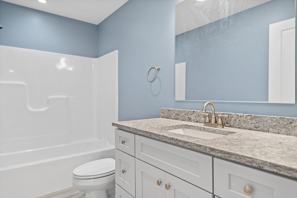 108 High Street, Unit B Wareham, MA 02571 - Photo 24 of 31 a bathroom with a granite countertop sink a toilet and a bathtub
