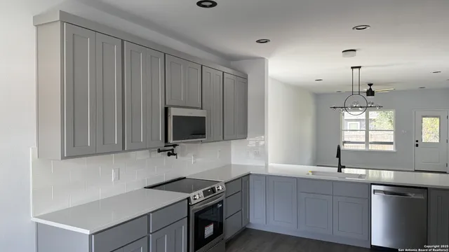 a kitchen that has a sink and a stove in it