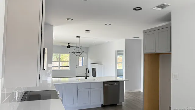 a large kitchen with a sink a refrigerator and window