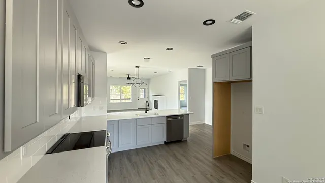 a large white kitchen with a sink and cabinets