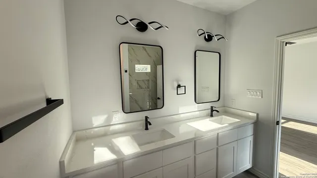 a bathroom with 2 sink and a mirror