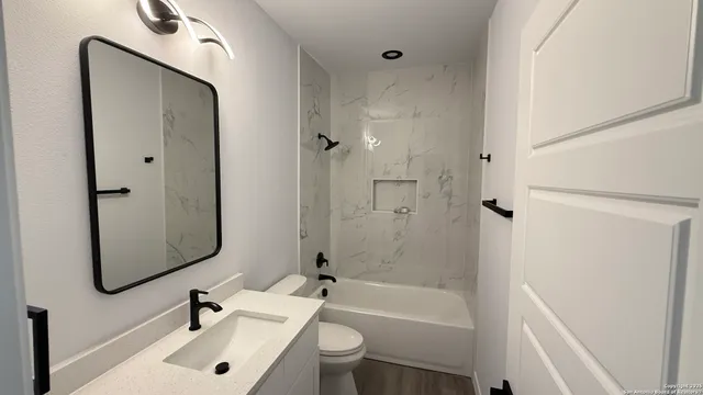 a bathroom with a sink toilet and shower