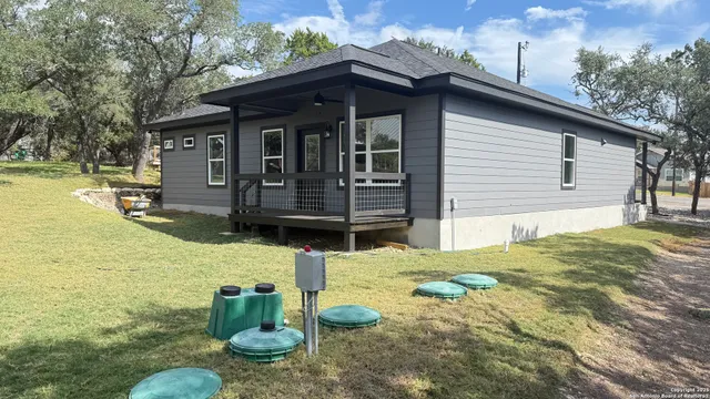 a backyard of a house with barbeque oven table and chairs