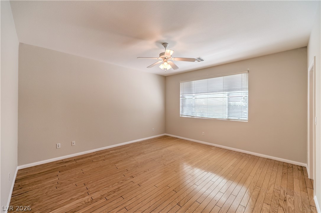 3713 Spring Shadow Road Las Vegas, NV 89129 - Photo 20 of 37 This naturally illuminated bedroom offers durable hardwood flooring and a functional ceiling fan for year-round comfort.