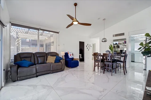 a living room with furniture a dining table and a chandelier
