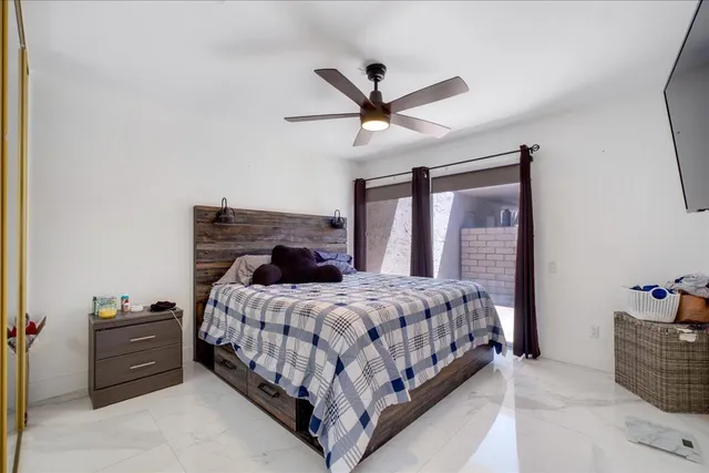 a bedroom with a bed and a ceiling fan