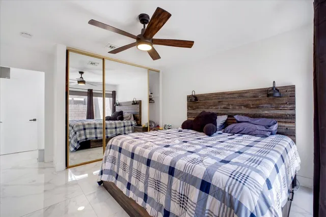 a bedroom with a large bed and a chandelier