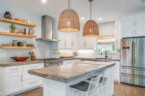 a kitchen with granite countertop a sink a refrigerator and wooden floor