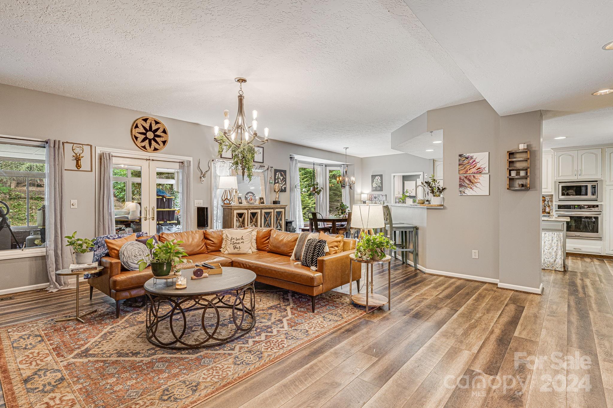 116 Holcombe Cove Road Candler, NC 28715 - Photo 13 of 31 a living room with furniture and a chandelier