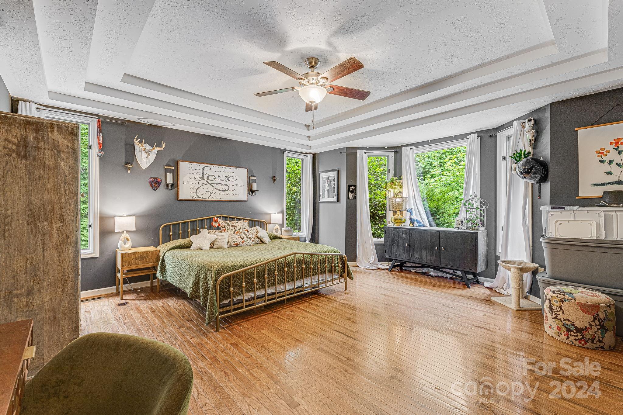116 Holcombe Cove Road Candler, NC 28715 - Photo 16 of 31 a spacious bedroom with a bed a couch and a window