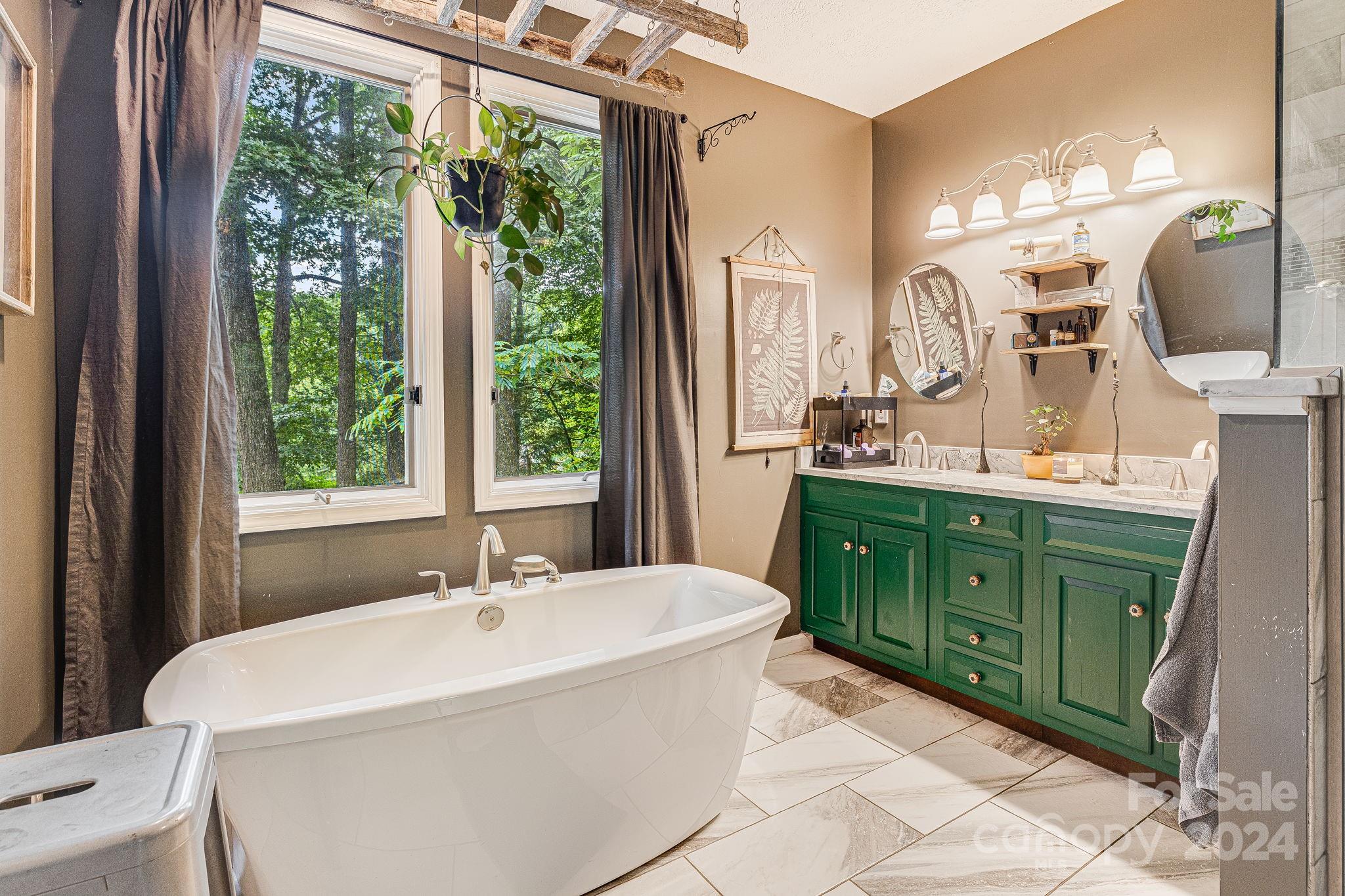 116 Holcombe Cove Road Candler, NC 28715 - Photo 17 of 31 a bathroom with a double vanity sink a mirror and a bathtub