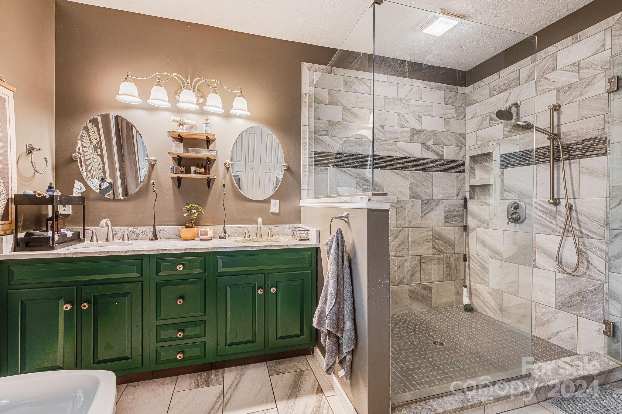116 Holcombe Cove Road Candler, NC 28715 - Photo 18 of 31 a bathroom with a double vanity sink mirror and shower