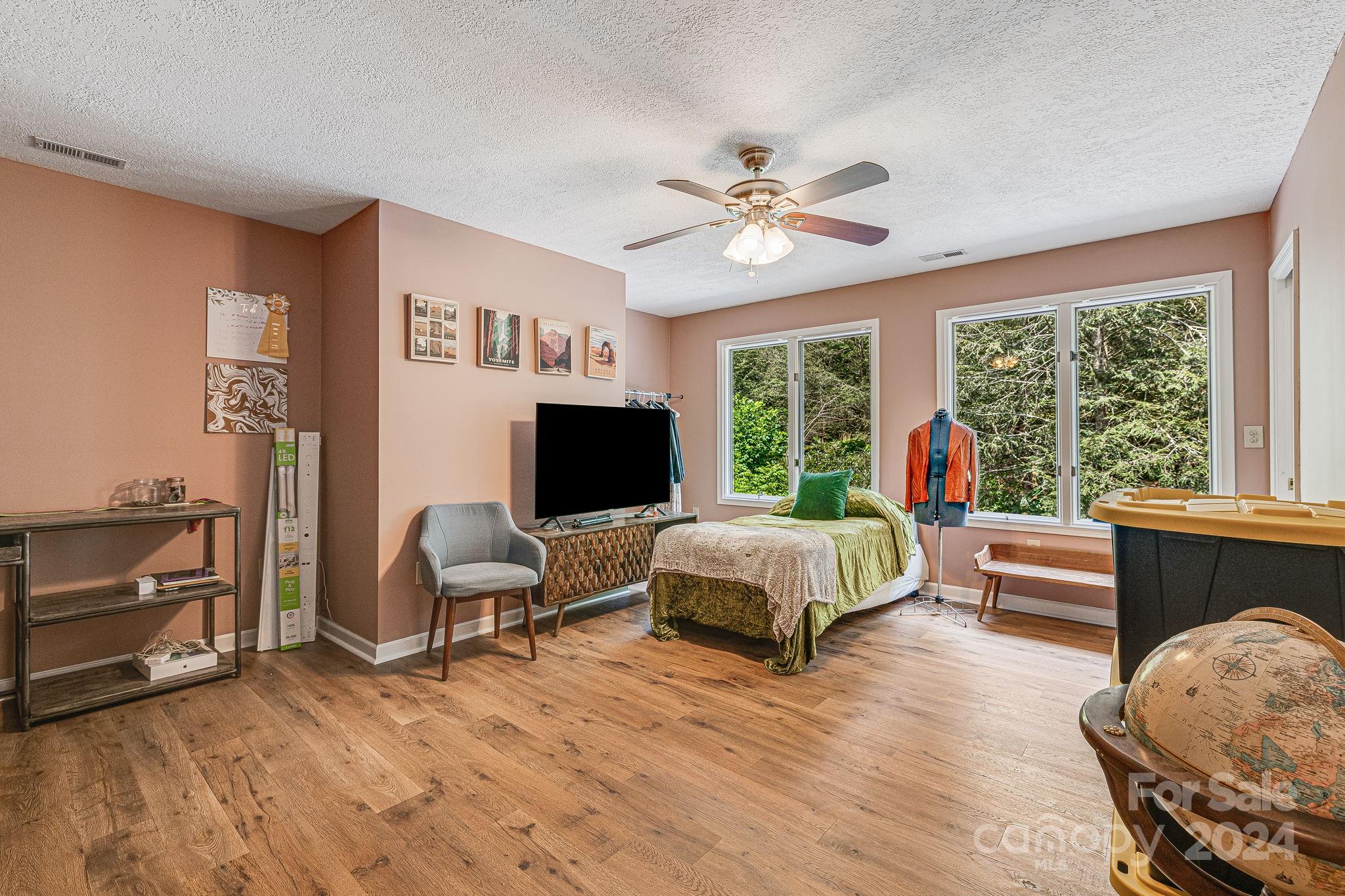 116 Holcombe Cove Road Candler, NC 28715 - Photo 25 of 31 a spacious bedroom with a bed and a flat screen tv