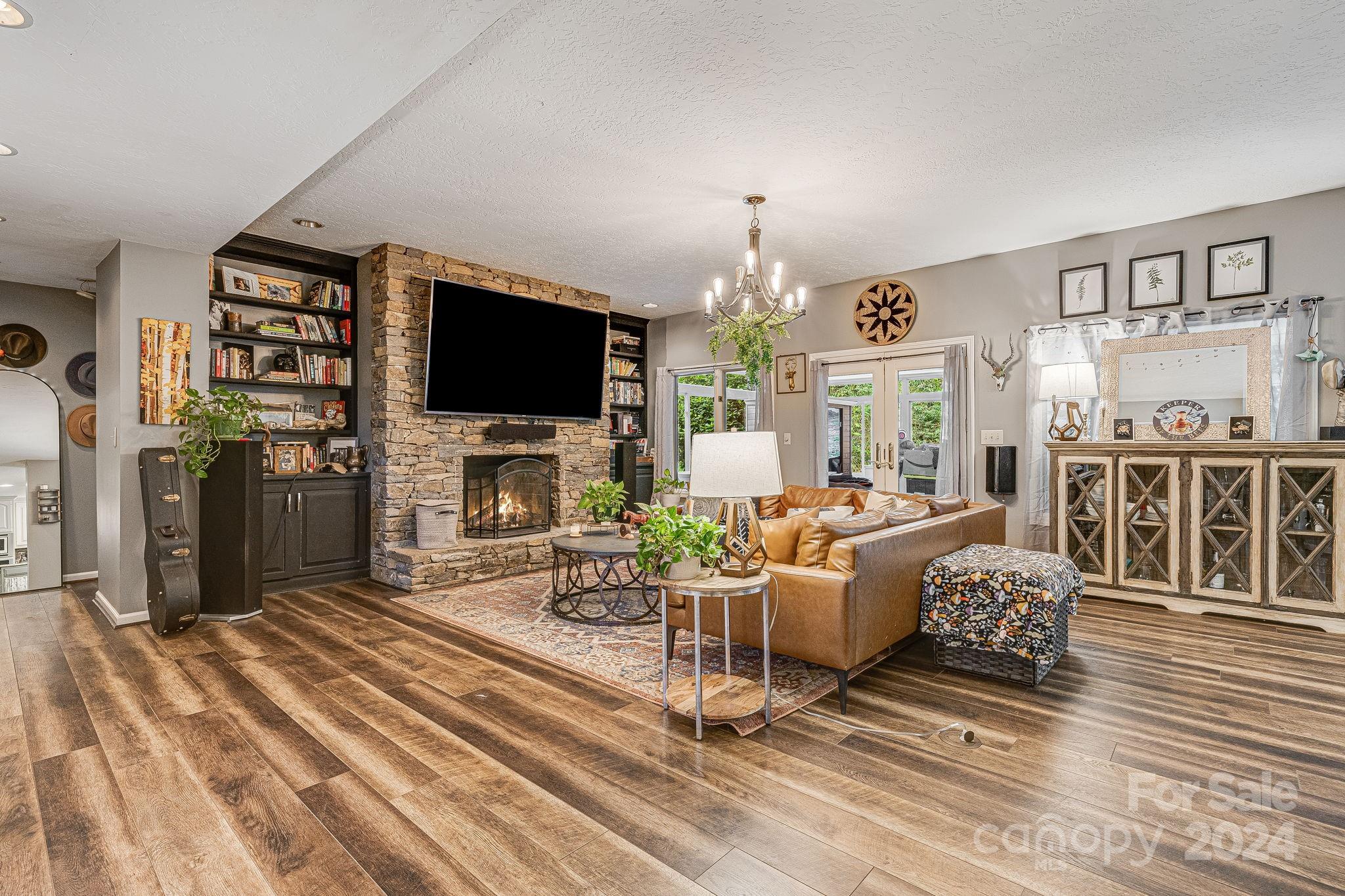 116 Holcombe Cove Road Candler, NC 28715 - Photo 6 of 31 a living room with furniture a fireplace and a flat screen tv