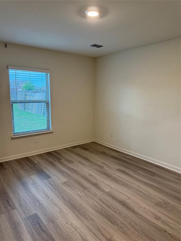 3010 McCoy Road Forney, TX 75126 - Photo 19 of 24 an empty room with wooden floor and windows