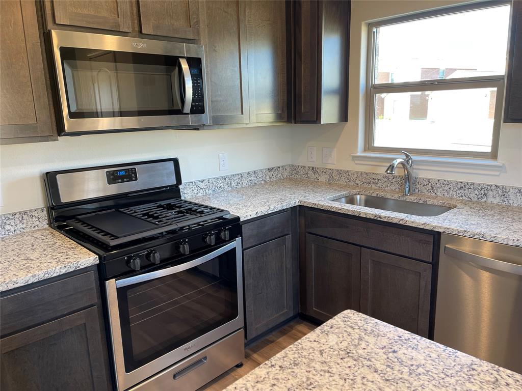 3010 McCoy Road Forney, TX 75126 - Photo 6 of 24 a kitchen with a stove microwave and sink