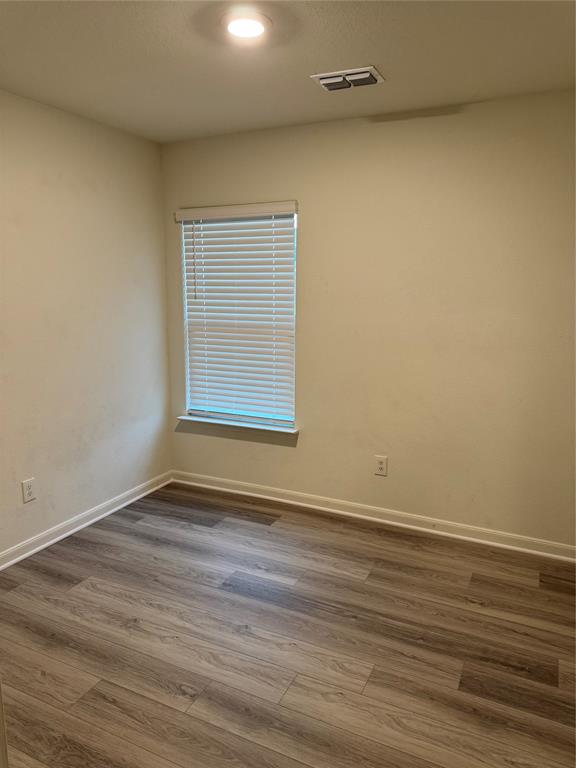3010 McCoy Road Forney, TX 75126 - Photo 10 of 24 a view of an empty room with wooden floor and a window