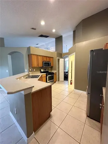 a kitchen with stainless steel appliances a refrigerator and a stove top oven